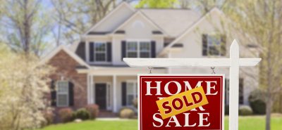 a home sold sign in front of a house.